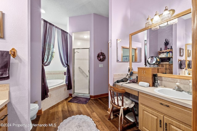 full bathroom with vanity, shower with separate bathtub, hardwood / wood-style floors, and a textured ceiling