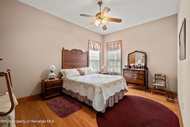 bedroom featuring a textured ceiling, light hardwood / wood-style flooring, and ceiling fan