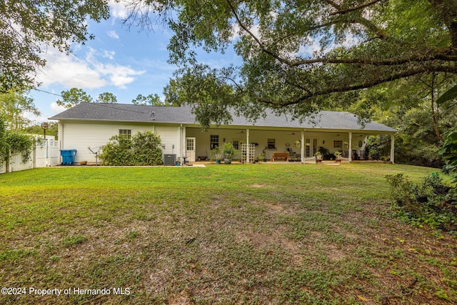 rear view of property with a patio, central air condition unit, outdoor lounge area, and a yard