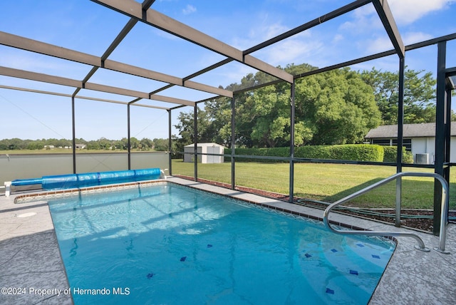 3391 Lambert Ave, Spring Hill, FL 34608 - view of swimming pool featuring a storage unit, a lanai, a yard, and a water view
