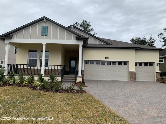 view of front of home with a garage, a porch, and a front lawn