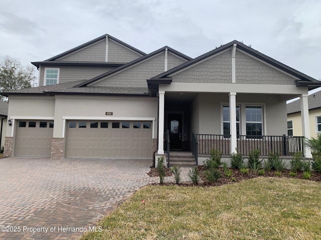 craftsman-style house with a front yard, a garage, and covered porch