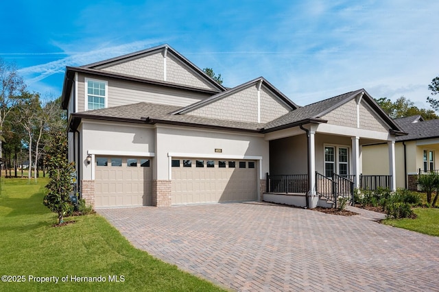 view of front of property with a garage, a front lawn, and a porch