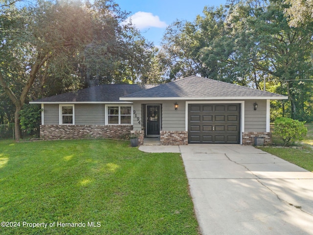 ranch-style house featuring a front yard and a garage