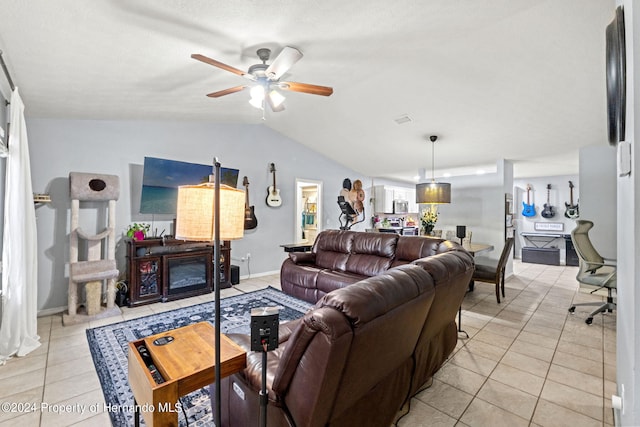 living room featuring vaulted ceiling, light tile patterned floors, and ceiling fan