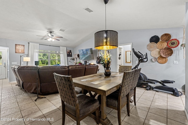 dining space with ceiling fan, vaulted ceiling, and light tile patterned floors