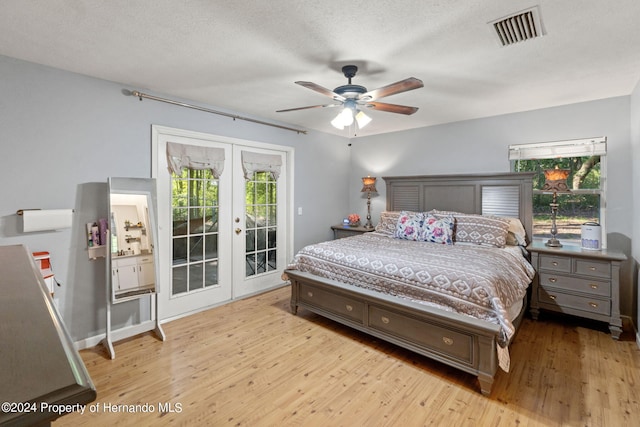 bedroom with multiple windows, light hardwood / wood-style flooring, and access to outside