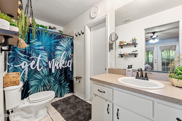 bathroom with tile patterned flooring, ceiling fan, a textured ceiling, vanity, and toilet