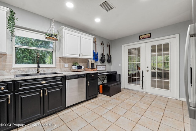 kitchen featuring stainless steel appliances, white cabinetry, sink, and tasteful backsplash