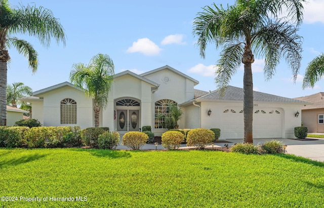 view of front of house with a garage and a front lawn