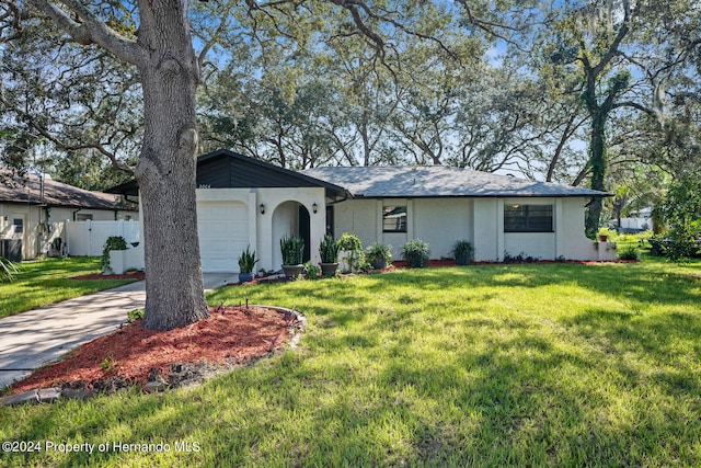 ranch-style house featuring a garage and a front yard