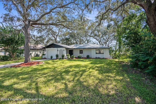 single story home featuring a garage and a front yard