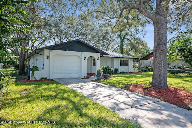 ranch-style home featuring a front lawn and a garage