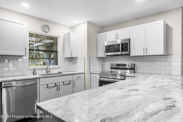 kitchen with white cabinetry, sink, appliances with stainless steel finishes, and tasteful backsplash