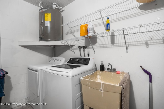 washroom with water heater, independent washer and dryer, sink, and a textured ceiling