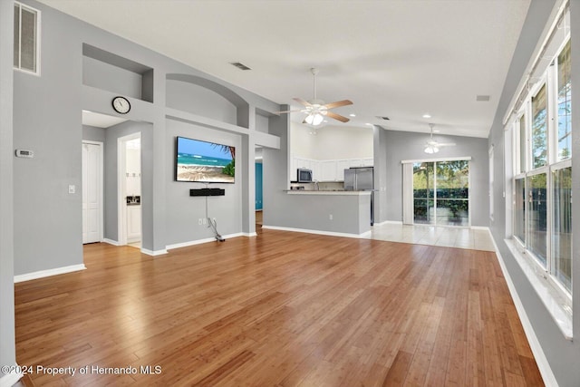 unfurnished living room featuring ceiling fan, light hardwood / wood-style flooring, and high vaulted ceiling