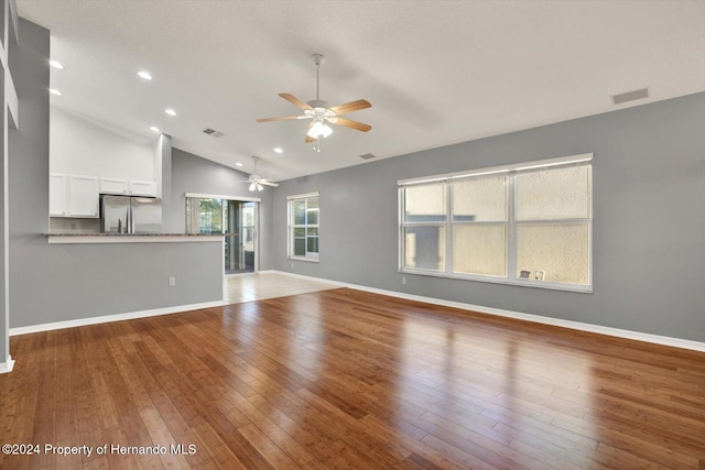 unfurnished living room featuring ceiling fan, wood-type flooring, and high vaulted ceiling