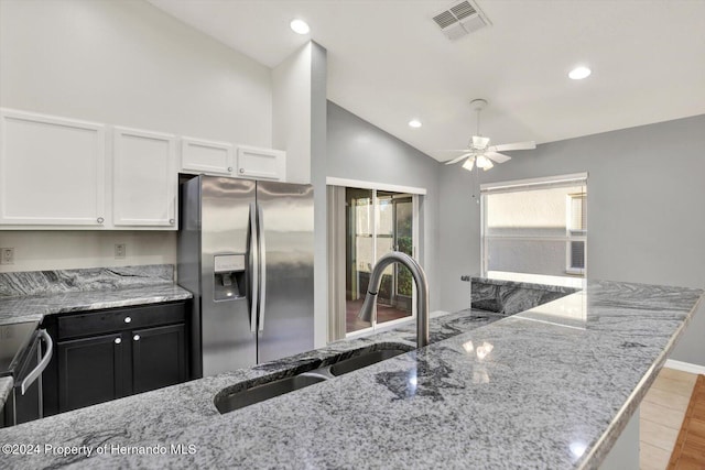 kitchen featuring white cabinetry, sink, light stone counters, vaulted ceiling, and appliances with stainless steel finishes