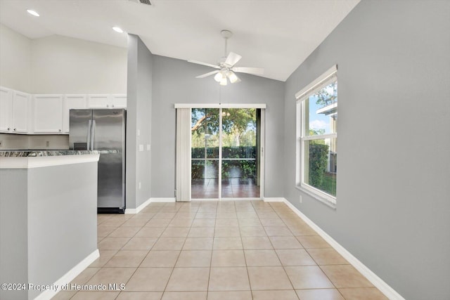 unfurnished dining area with ceiling fan, lofted ceiling, and light tile patterned floors