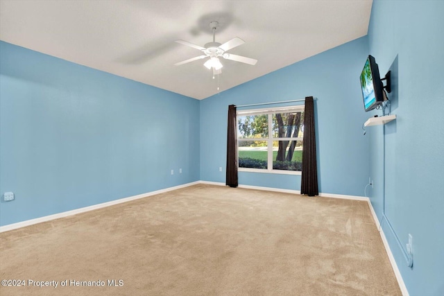 carpeted empty room with ceiling fan and vaulted ceiling