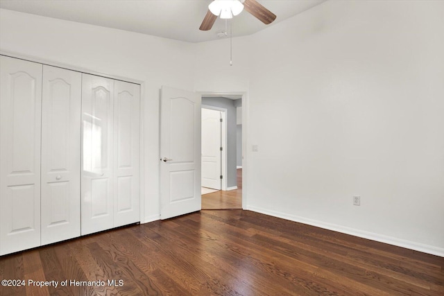 unfurnished bedroom featuring dark hardwood / wood-style floors, ceiling fan, and a closet