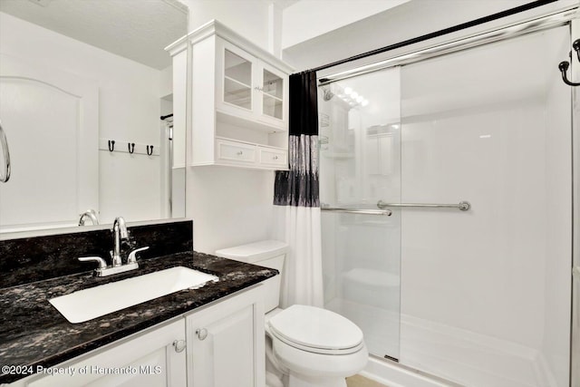 bathroom with vanity, an enclosed shower, and toilet