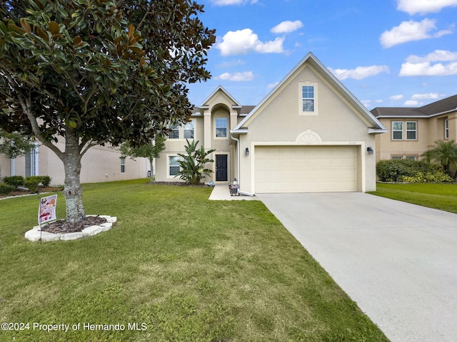 front of property with a garage and a front lawn