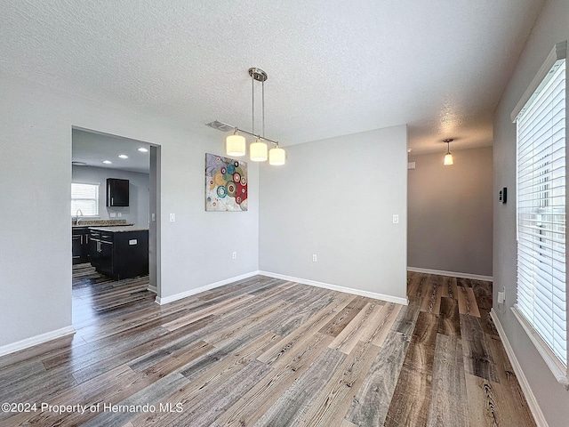 empty room with a textured ceiling, dark hardwood / wood-style floors, and sink