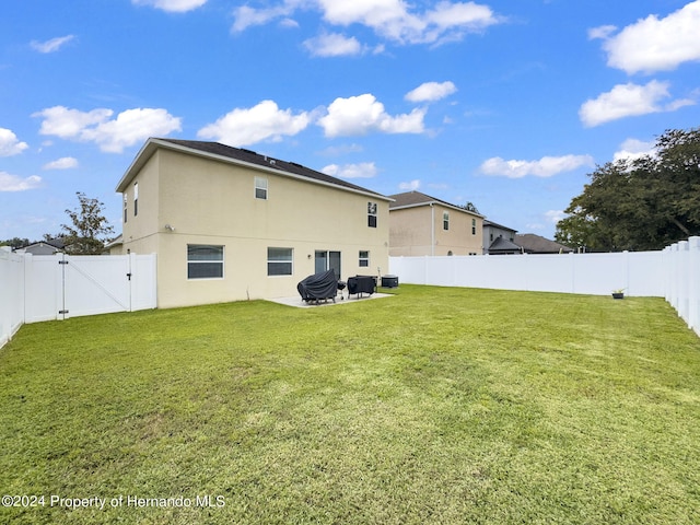 back of house with a lawn and a patio area