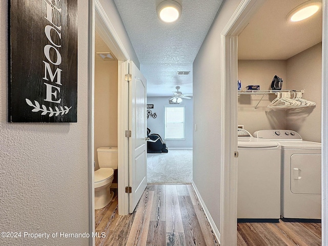 clothes washing area featuring hardwood / wood-style floors, ceiling fan, a textured ceiling, and washer and clothes dryer