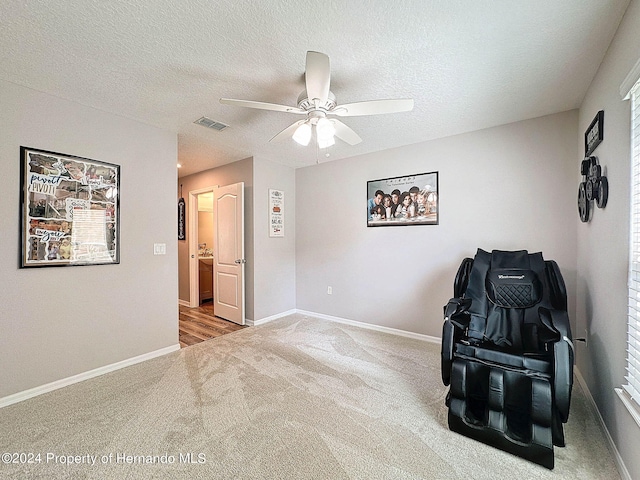 sitting room featuring carpet flooring, a textured ceiling, and ceiling fan