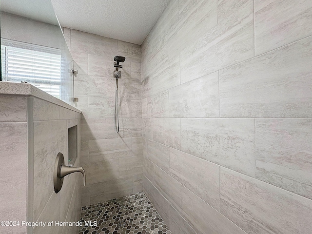 details featuring a textured ceiling and a tile shower