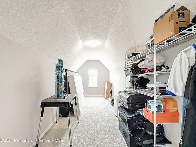 walk in closet featuring light carpet and vaulted ceiling