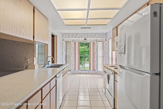 kitchen with stainless steel appliances, light tile patterned flooring, sink, and light brown cabinets