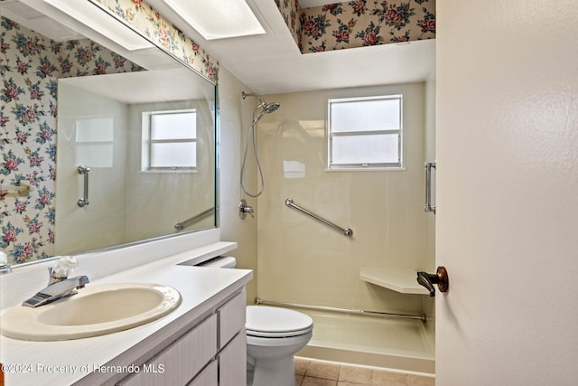 bathroom with a wealth of natural light, vanity, toilet, and walk in shower