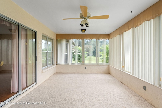 unfurnished sunroom with ceiling fan