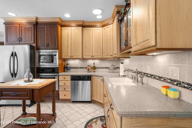 kitchen with a textured ceiling, stainless steel appliances, sink, and backsplash