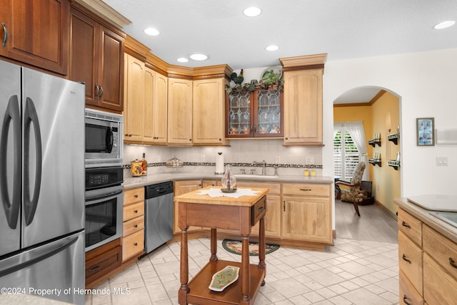 kitchen with sink, appliances with stainless steel finishes, and decorative backsplash