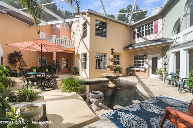 back of house with a lanai and a patio area