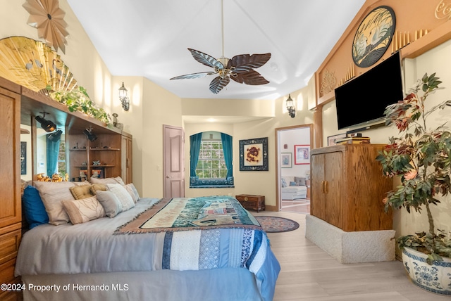 bedroom with connected bathroom, light wood-type flooring, and ceiling fan