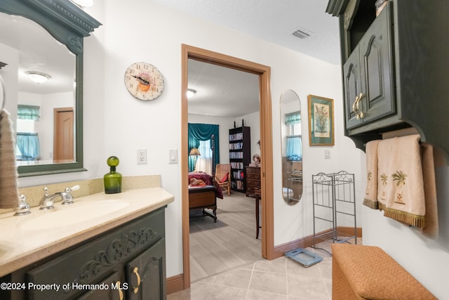 bathroom featuring vanity, a textured ceiling, and tile patterned floors