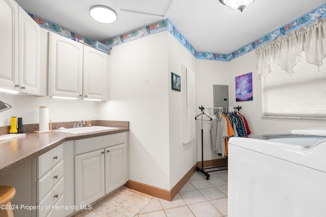 laundry room with electric panel, light tile patterned floors, cabinets, sink, and washing machine and dryer