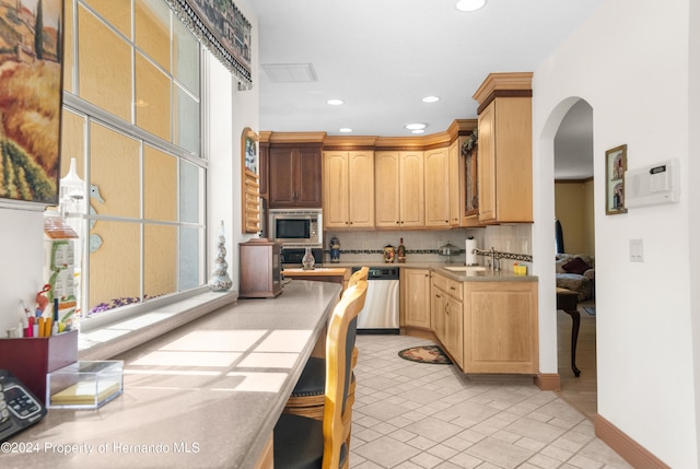 kitchen featuring tile counters, sink, tasteful backsplash, light tile patterned flooring, and appliances with stainless steel finishes