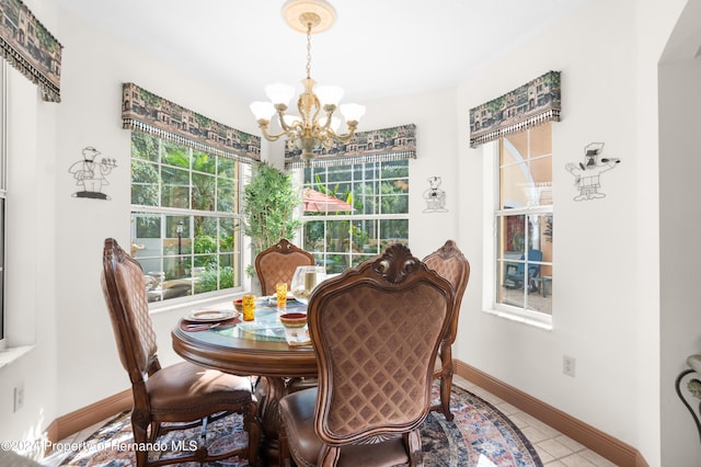 tiled dining room with a wealth of natural light and an inviting chandelier