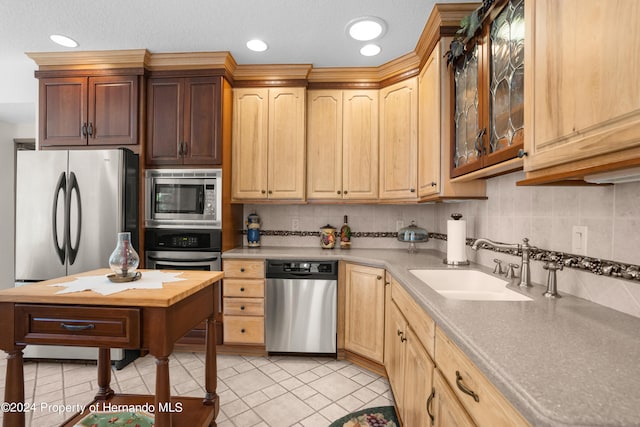 kitchen featuring stainless steel appliances, sink, and backsplash