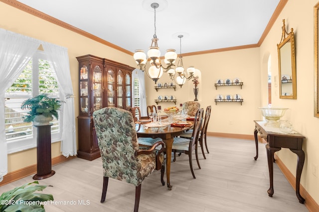 dining space featuring light hardwood / wood-style flooring, crown molding, and an inviting chandelier