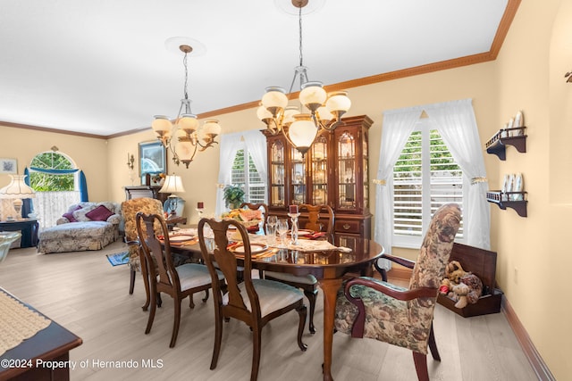 dining space featuring ornamental molding, light hardwood / wood-style flooring, and a chandelier