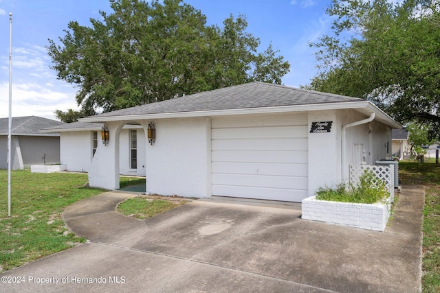 ranch-style house featuring a garage and a front yard