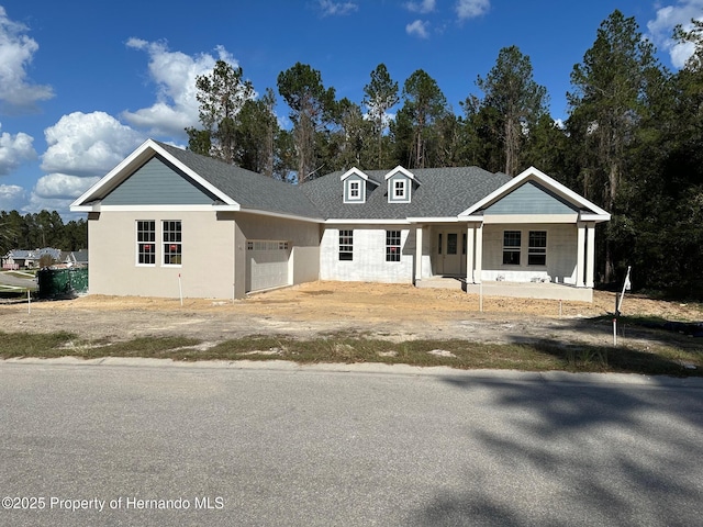 view of front of property featuring covered porch and a garage