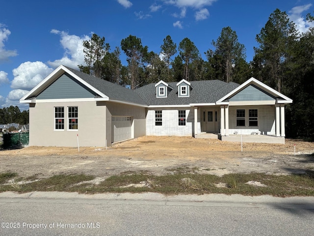 view of front of property featuring covered porch and a garage